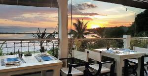 a table and chairs on a balcony with a sunset at Marina 4Rooms in San Vicente