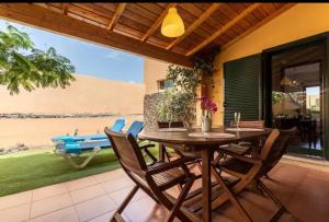 drewniany stół i krzesła na patio w obiekcie Vivienda Vacacional Orquidea w Corralejo