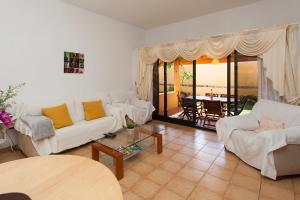 コラレホにあるVivienda Vacacional Orquideaの白い家具付きのリビングルームが備わり、海の景色を望めます。