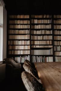 een kamer met boekenplanken en een tafel en stoelen bij Huize Schaberg in Borgloon