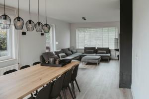 sala de estar con mesa y sofá en Villa Bandi - Group & Family House en Lanaken