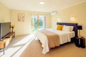 una camera con letto e TV a schermo piatto di The waterfront 361-Family retreat with Netflix Skysport Air conditioner in each bedroom ad Auckland