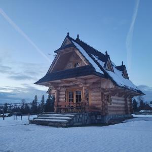 uma cabana com neve no telhado em Domek u Beaty em Dzianisz