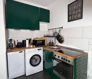 eine Küche mit einer Waschmaschine und einer Waschmaschine in der Unterkunft Ruhig & Zentral - 2 Kingsize Betten - Wi-Fi in Essen