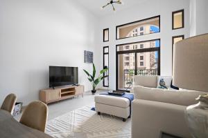 a living room with a couch and a tv at Stylish 1BR Apt Umm Suqeim 3 in Dubai