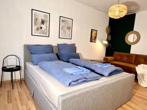 ein Bett mit blauen Kissen darauf im Wohnzimmer in der Unterkunft Ruhig & Zentral - 2 Kingsize Betten - Wi-Fi in Essen