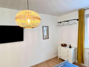 a room with a chandelier and a tv on a wall at Ruhig & Zentral - 2 Kingsize Betten - Wi-Fi in Essen