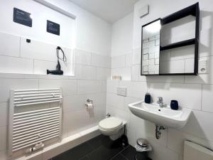 a white bathroom with a toilet and a sink at Ruhig & Zentral - 2 Kingsize Betten - Wi-Fi in Essen