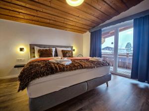 a bedroom with a large bed with blue curtains at Gruppenhaus Alpenglück in Kirchdorf in Tirol