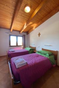 a room with two beds and a wooden ceiling at OASI FRANCESCANA SANT'IGNAZIO DA LACONI in Làconi