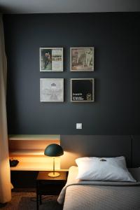 a bedroom with a black wall with a bed and a desk at Hotel Navalis, Klaipėda in Klaipėda