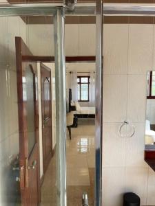 a hallway with a glass door and a living room at The Jewel and the Lake in Jinja