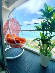 a swinging chair on a balcony with a window at The Song Vung Tau Near Beach by Hoang Gia in Vung Tau