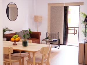 sala de estar con mesa y sofá en Elegant apartment with private workspace, en Candelaria