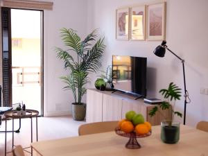 sala de estar con TV y mesa con fruta en Elegant apartment with private workspace, en Candelaria