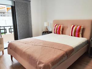 1 dormitorio con 1 cama con 2 almohadas y ventana en Elegant apartment with private workspace, en Candelaria