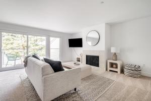 a white living room with a couch and a fireplace at Sharon Green apartments by FantasticStay in Menlo Park
