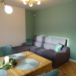 a living room with a couch and a table at Apartamenty u ROXI in Jelenia Góra