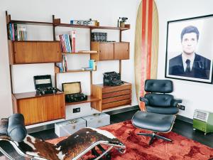 a living room with a chair and a picture of a man at Bonvalot Guest House in Paço de Arcos