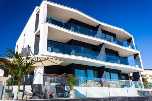 a large white building with blue balconies at Villa Valis in Baška