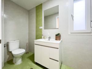 y baño con aseo, lavabo y espejo. en Apartamentos Gredos 104 en Jaraiz de la Vera