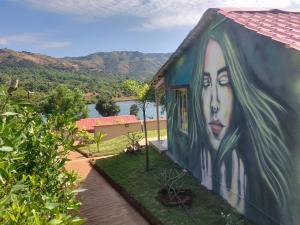 une peinture d'une femme sur le côté d'un bâtiment dans l'établissement VRISA Mountain Retreat, à Pune