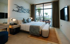 - une chambre avec un lit, un bureau et une télévision dans l'établissement Bab Al Nojoum Hudayriyat Villas, à Abu Dhabi
