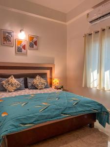 a bedroom with a bed with a blue comforter at 3BHK Home in Anjuna by Arzu Homes in Anjuna