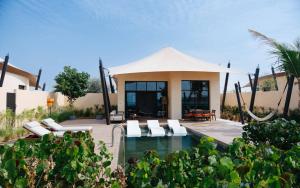a villa with a swimming pool and a house at Bab Al Nojoum Hudayriyat Villas in Abu Dhabi