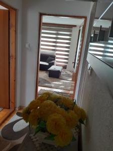 a vase filled with yellow flowers in a hallway at Apartman Begić in Travnik