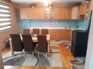 a kitchen with a wooden table with chairs and a sink at Apartman Begić in Travnik