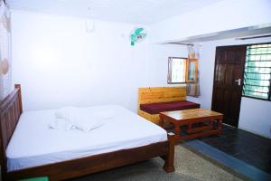 Dormitorio pequeño con cama y mesa en The Nest Resort Shanzu, en Mombasa