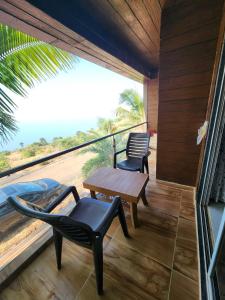 a balcony with a table and a chair and a view at Seascape Villa in Ānjarle