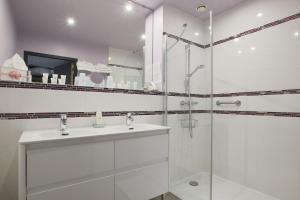 a white bathroom with a sink and a shower at Le Clos du Moulin in Vaudemanges +23 photos