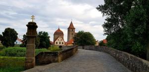 eine Steinbrücke mit einer Kirche und einem Kreuz darauf in der Unterkunft Fewo 1 - Seehaus Hoyer in Gunzenhausen