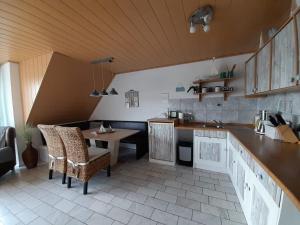 eine Küche mit einem Tisch und Stühlen im Zimmer in der Unterkunft Fewo 1 - Seehaus Hoyer in Gunzenhausen