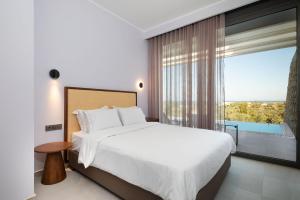 ein Schlafzimmer mit einem großen Bett und einem großen Fenster in der Unterkunft Z 4 LUXURY VILLAS in Lefkada Town