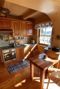 a kitchen with wooden cabinets and a wooden table at Nasza Chata in Jaworzynka
