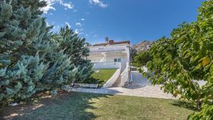 a white house with trees in front of it at Große Terrasse mit Meerblick, Strand 200 Meter in Baška