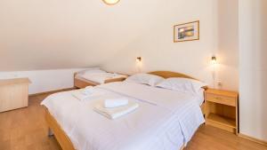 a bedroom with a white bed with two towels on it at Große Terrasse mit Meerblick, Strand 200 Meter in Baška