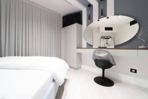 a bedroom with a bed and a mirror and a chair at Sweet Love - דירה מהממת על הטיילת בבת ים עם נוף מושלם in Bat Yam