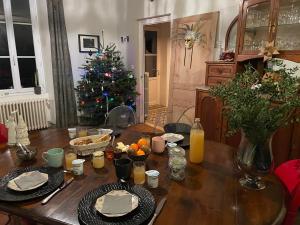 - une table avec un arbre de Noël dans le salon dans l'établissement Chez Guilem, à Saint-Maixent-lʼÉcole
