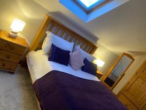 ein Schlafzimmer mit einem großen Bett mit blauen und weißen Kissen in der Unterkunft The Barn in Haxby