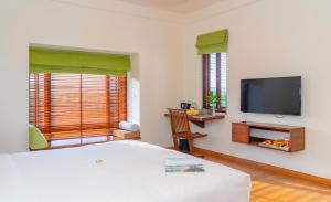 a bedroom with a bed and a flat screen tv at Elites Riverside Hotel & Spa Hoi An in Hoi An