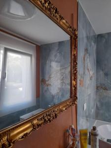 espejo colgado en la pared del baño en Casa Al Borghetto en Oriago