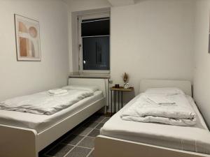 2 camas en una habitación con ventana en FeWo Carl: Businessapartment mit Stil, en Bielefeld