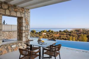 een patio met stenen muren en een tafel en stoelen bij Z 4 LUXURY VILLAS in Lefkada