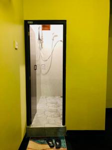 a mirror in a yellow room with a shower at Ella Brown House in Ella