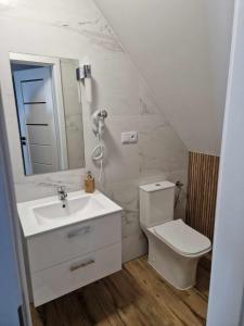 a white bathroom with a sink and a toilet at Widokowa Polana in Szaflary