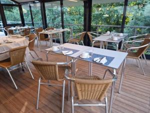 um restaurante com mesas e cadeiras num deque em Quinta Do Moinho Turismo de Natureza em Aldeia Viçosa